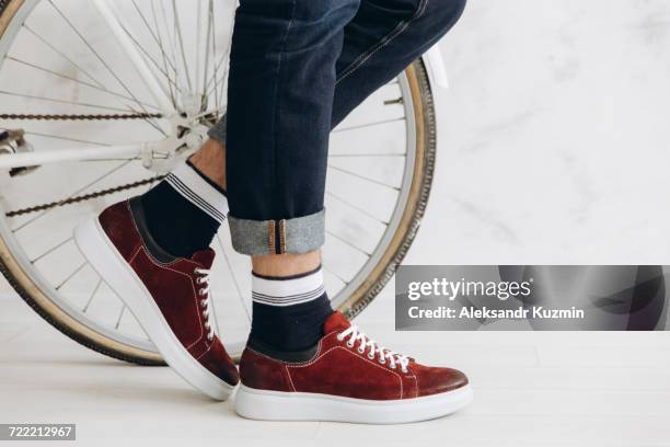 legs of man standing near bicycle wheel - shoes man stock pictures, royalty-free photos & images