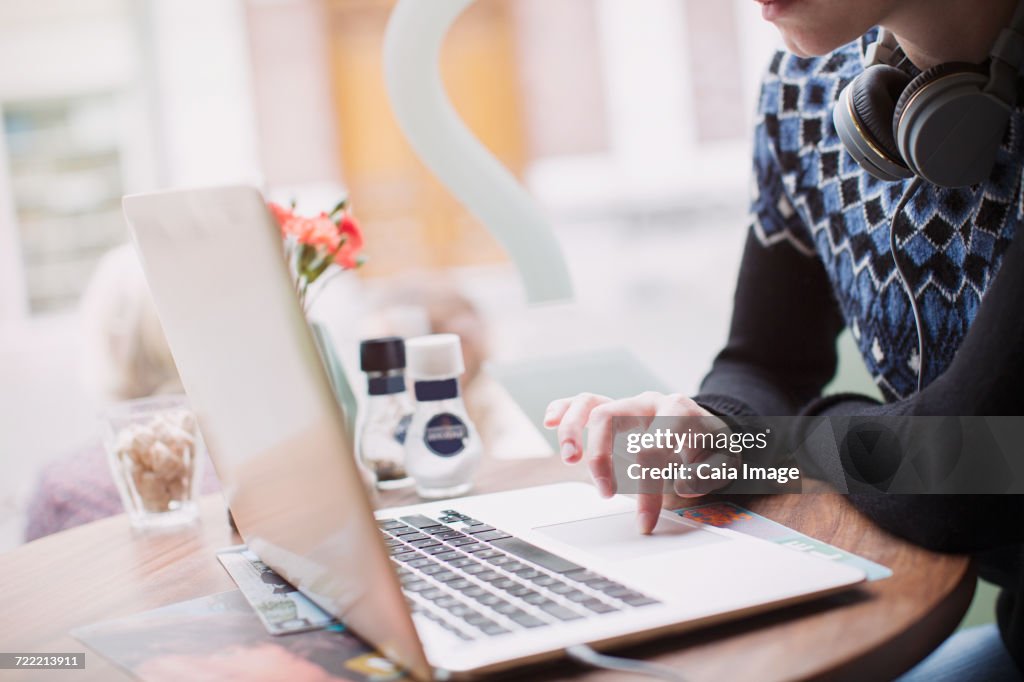 Woman using laptop at cafe window