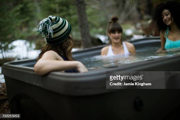 three friends relaxing in hot tub - girls in hot tub stockfoto's en -beelden
