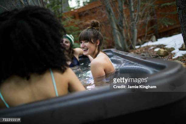 three friends relaxing in hot tub - girls in hot tub - fotografias e filmes do acervo