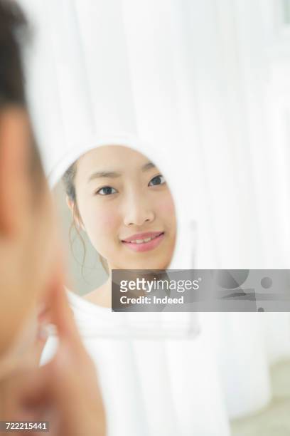 reflection of young woman in hand mirror - 若い女性 日本人 顔 ストックフォトと画像