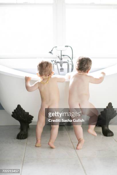rear view of male and female toddlers looking into bathtub - no clothes girls stock pictures, royalty-free photos & images
