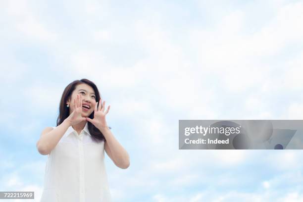 young woman shouting under the sky - 叫ぶ ストックフォトと画像