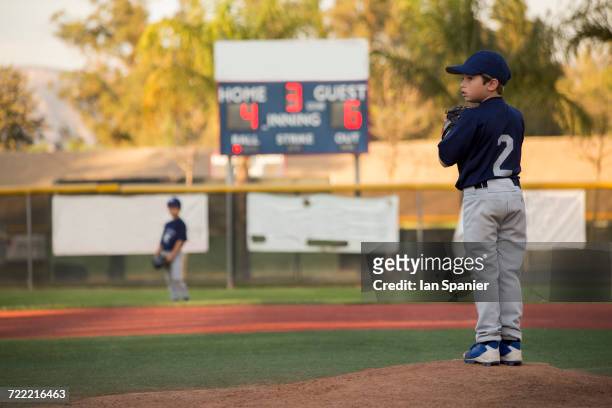 boy baseball pitcher preparing to throw on baseball field - kid baseball pitcher stock pictures, royalty-free photos & images