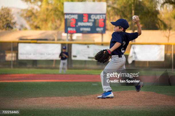 boy baseball pitcher throwing ball on baseball field - baseball tee stock pictures, royalty-free photos & images