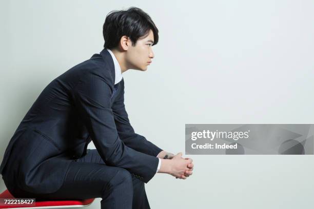 side view of young businessman sitting on chair - 横顔　男性 ストックフォトと画像