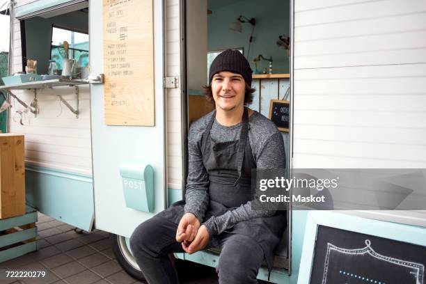 portrait of smiling male owner sitting in food truck on street - straßenverkäufer stock-fotos und bilder