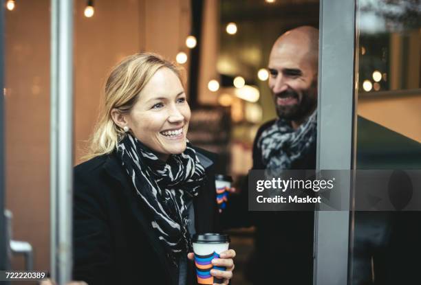 smiling mid adult businesswoman and businessman leaving cafe - businesswoman blond looking left foto e immagini stock