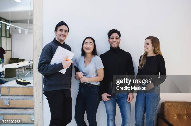 portrait of four happy people in creative office - four people stock-fotos und bilder