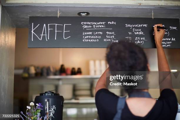 rear view of waitress writing on blackboard at cafe - menu board stock pictures, royalty-free photos & images