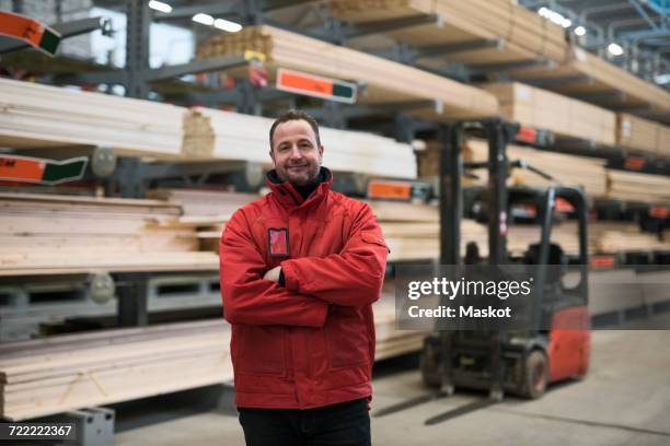 portrait of confident salesman standing arms crossed at hardware store warehouse - sales assistant furniture stock pictures, royalty-free photos & images