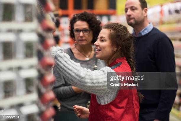 side view of smiling saleswoman assisting mature couple in hardware store - marketing tools photos et images de collection