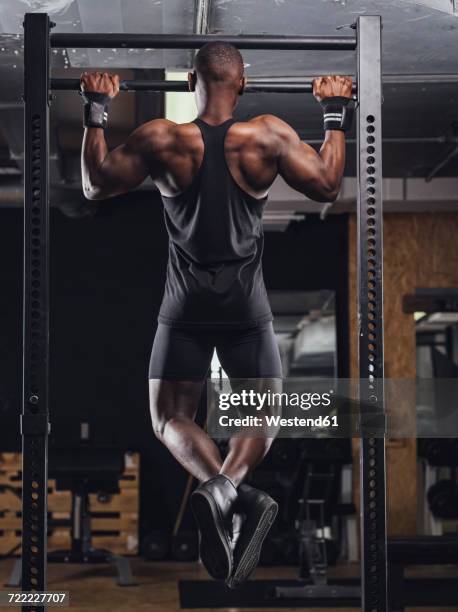 athlete doing push ups in gym - chin ups stockfoto's en -beelden