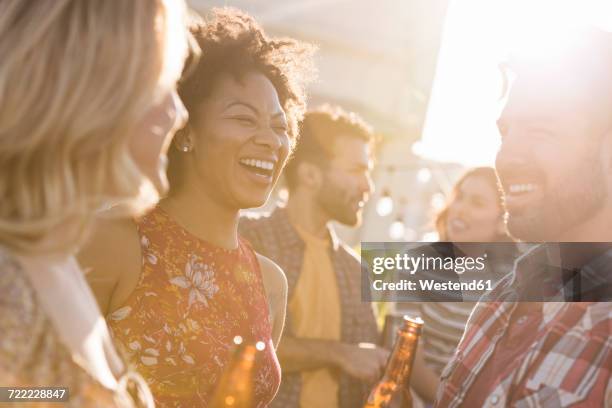 friends having a rooftop party, chatting and drinking beer - roof garden stock pictures, royalty-free photos & images