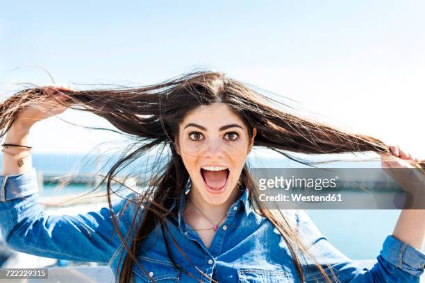 portrait of screaming young woman pulling her hair - human hair stockfoto's en -beelden