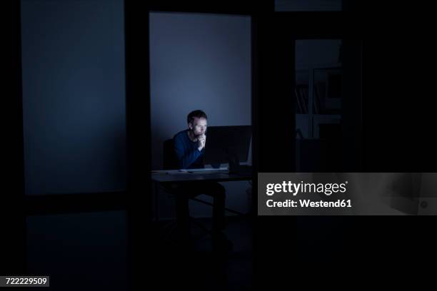 man working late in office - alone office night stockfoto's en -beelden