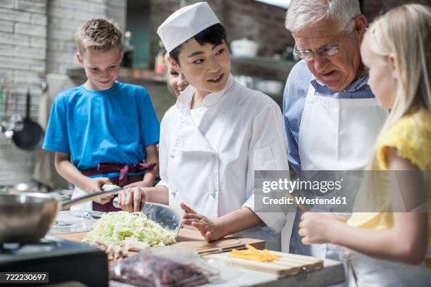 female chef instructing kids in cooking class - children cooking school stock-fotos und bilder