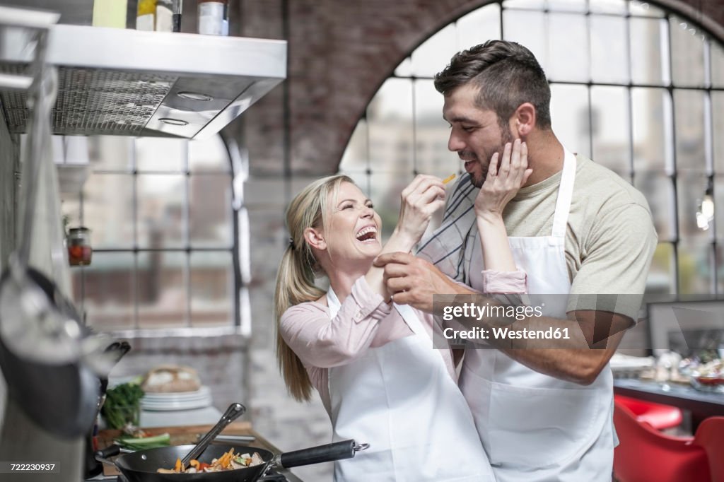 Couple cooking together and having fun in kitchen