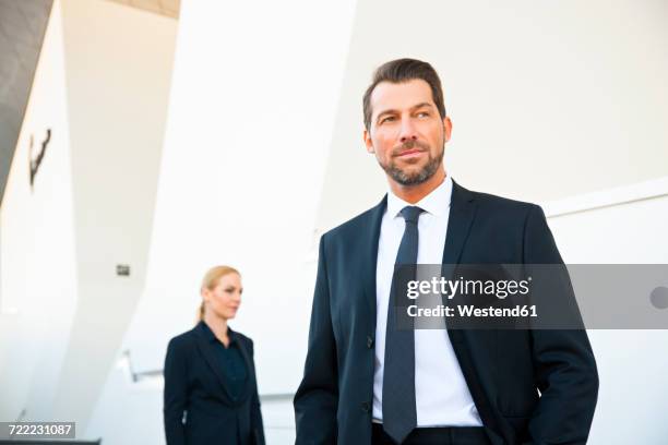 confident businessman and businesswoman outside office building - arrogant stock-fotos und bilder