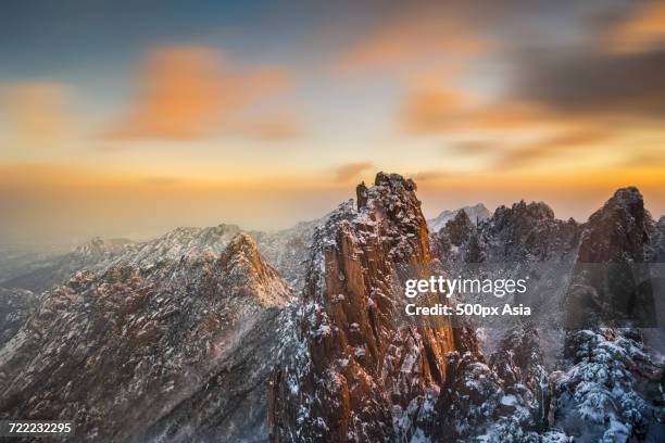 mountain with steep cliffs covered in snow at sunset, mount huangshan, anhui, china - huangshan bildbanksfoton och bilder