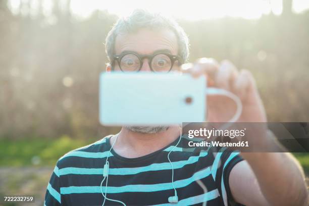 starring man taking picture of viewer with smartphone - staring stock pictures, royalty-free photos & images