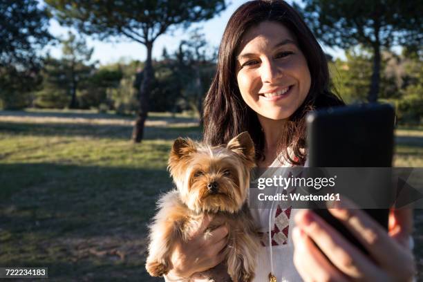 happy young woman taking selfie with her dog - terrier du yorkshire photos et images de collection