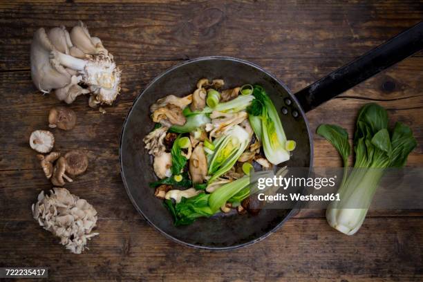 stir-fry with chinese cabbage, maitake, oyster and shitake mushrooms in pan - roerbakken stockfoto's en -beelden