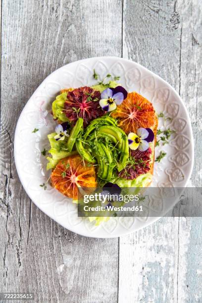 toast garnished with iceberg salad, avocado, sliced blood orange, cress and horned violets - comida flores fotografías e imágenes de stock