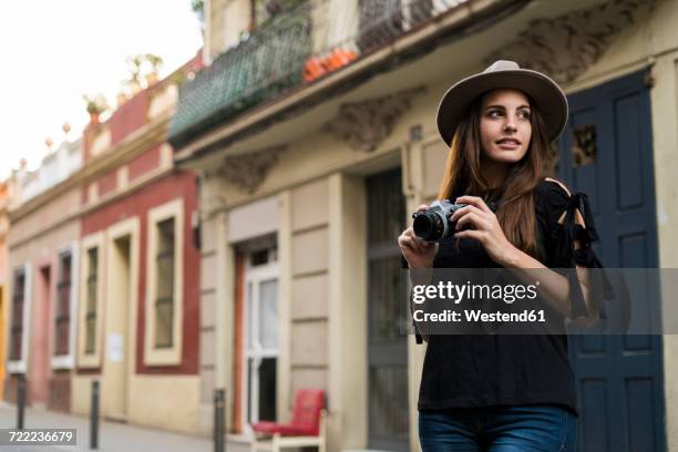 portrait of smiling young woman with camera outdoors - fashion photographer stock pictures, royalty-free photos & images