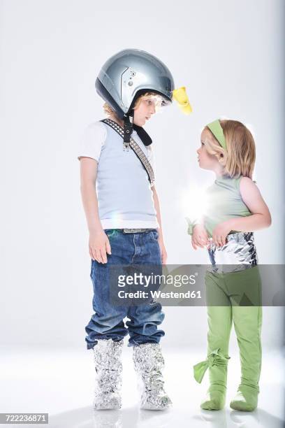 boy dressed up as spaceman getting in contact with girl dressed up as alien - yoghurt pot stock pictures, royalty-free photos & images