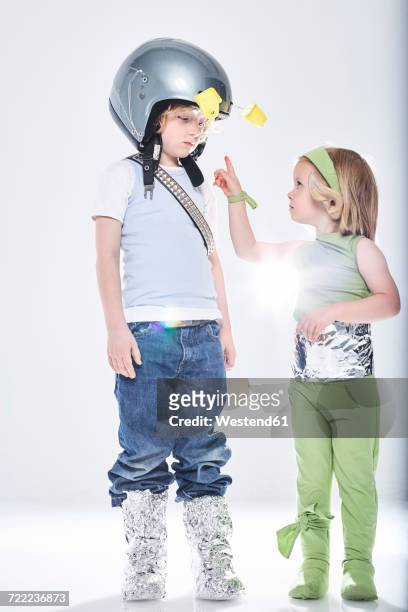girl dressed up as alien getting in contact with boy dressed up as spaceman - yoghurt pot stock pictures, royalty-free photos & images