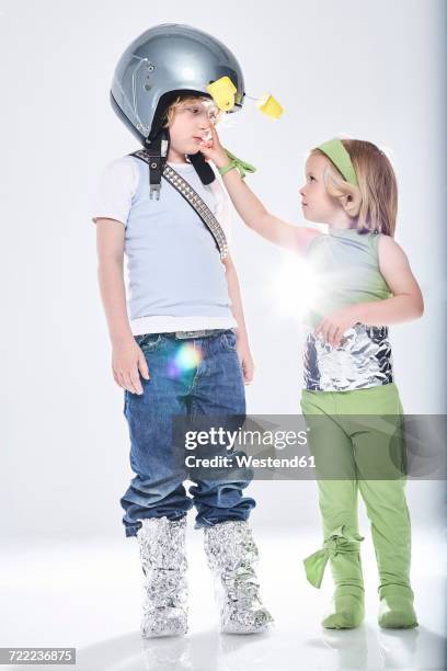 girl dressed up as alien getting in contact with boy dressed up as spaceman - yoghurt pot stock pictures, royalty-free photos & images