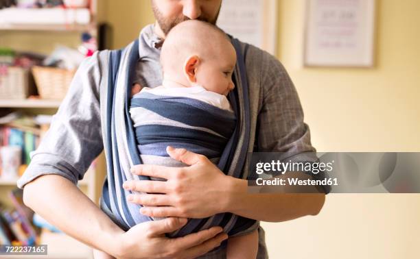 father with baby son in sling at home - stay at home father stock pictures, royalty-free photos & images