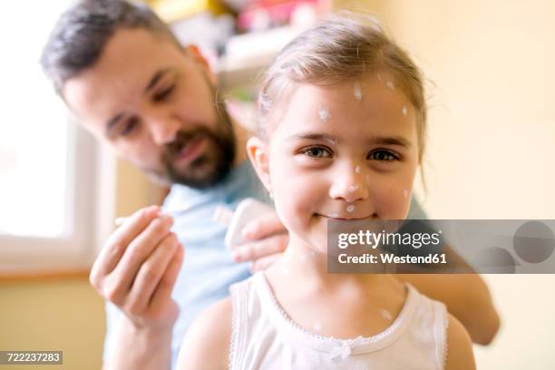 father at home caring for daughter having chickenpox - irritation cutanée photos et images de collection