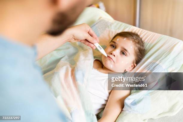 father at home caring for daughter having chickenpox - gram stain stock-fotos und bilder
