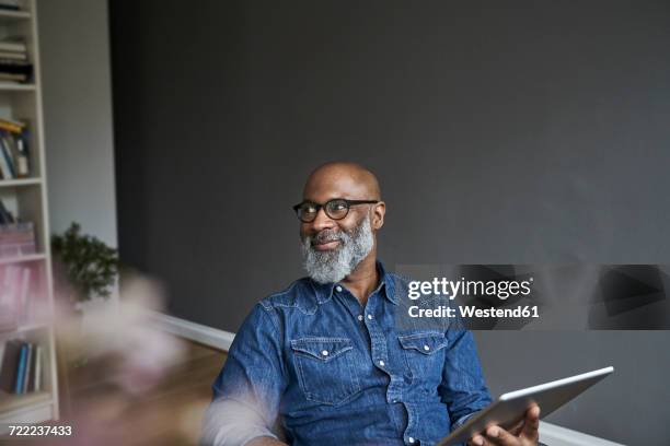 mature man holding tablet, smiling - fashion for peace stock pictures, royalty-free photos & images