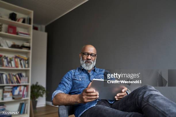 mature man using digital tablet - usare un tablet foto e immagini stock