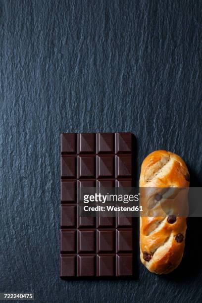 bittersweet chocolate bar and chocolate bun on slate - bread texture stockfoto's en -beelden