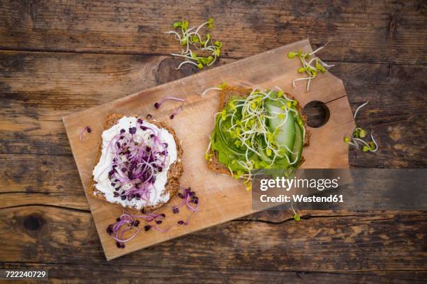 cream cheese sandwich and sandwich with avocado cream garnished with radish sprouts - vollkornbrot stock-fotos und bilder