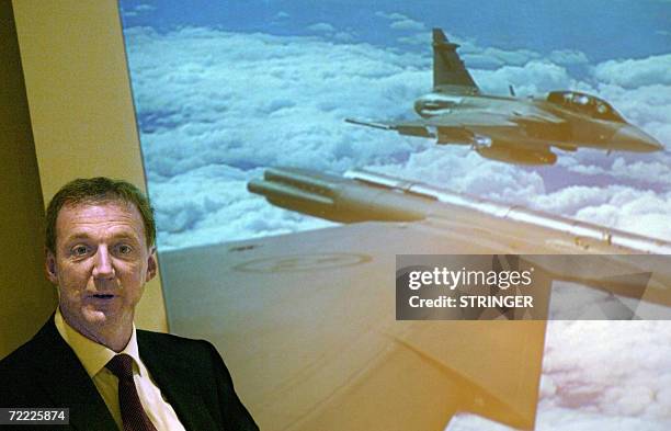 Swedish aerospace and defense company Saab AB Chief Executive Ake Svensson poses in front of a photo of the company's JAS-39 Gripen fighter jet...