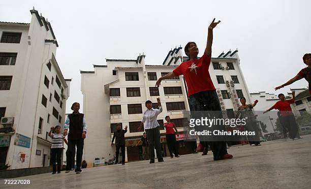 Relocated residents dance on a square at the new site of Dachang Township on October 20, 2006 in Wushan County of Chongqing Municipality, China. The...