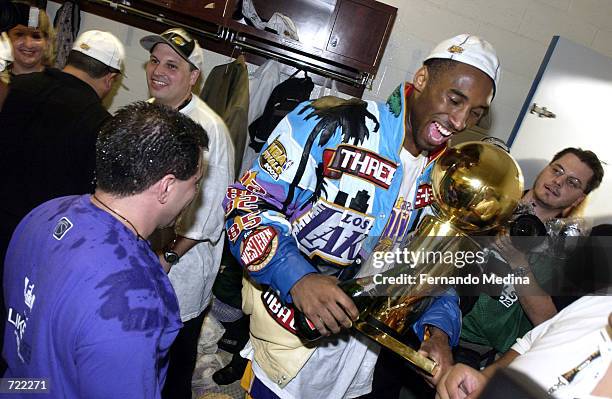 Kobe Bryant of the Los Angeles Lakers celebrates with the Larry O'Brien Championship trophy after defeating the New Jersey Nets in the 2002 NBA...