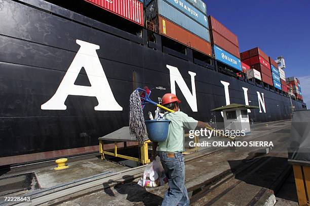 Worker walks next to the cargo ship Hanjin anchored at one of the three locks of the Gatun lake in the Atlantic gate of the Panama Canal 20 October...