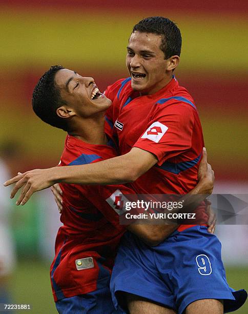 San Salvador, EL SALVADOR: Costa Rican Marcos Urena Porras celebrates with an unidentify teammate after scored against Nicaragua during a match 20...