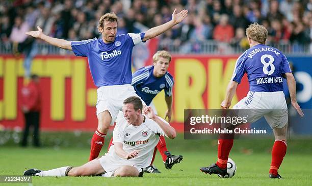 Marcel Eger of Pauli competes with Michael Molata and Christian Mikolajczak of Holstein Kiel during the third league match between Holstein Kiel and...