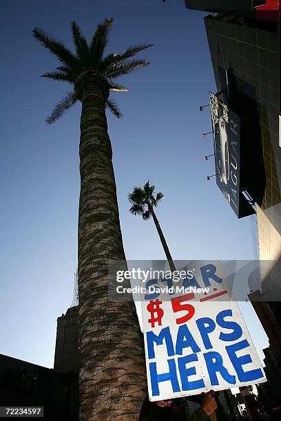 Palm tree towers over a man selling maps to celebriies' homes at Hollywood and Highland as many of the area?s palms fade into history because of a...