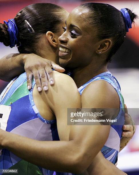 Daiane dos Santos of Brazil celebrates with Lais Souza after she performs on the floor in the the womens individual finals during the World Artistic...