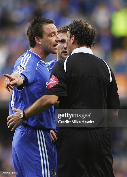 John Terry of Chelsea talks to referee Mark Clattenburg as team mate Andriy Shevchenko is booked for over-celebrating during the Barclays Premiership...