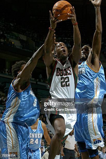 Michael Redd of the Milwaukee Bucks shoots a layup agasint Yakhouba Diawara and Joe Smith of the Denver Nuggets October 21, 2006 at the Bradley...