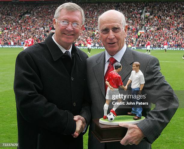 Sir Bobby Charlton is presented with a statue by Sir Alex Ferguson to commemorate the 50th anniversary of his Manchester United debut ahead of the...